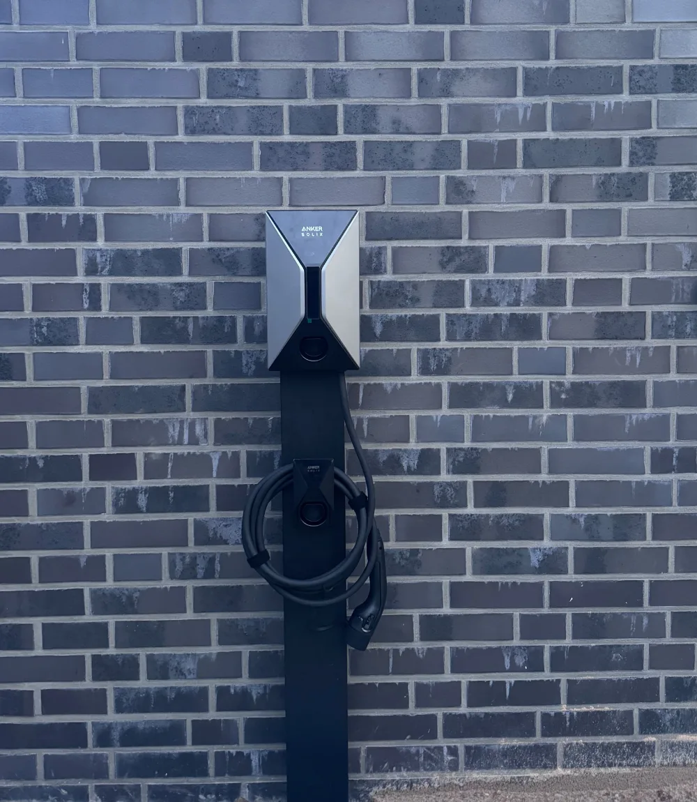 Wallbox Montage an der Hauswand: Anker SOLIX Ladestation für Elektroauto auf Standfuß mit Kabelhalter, installiert von Daelon
